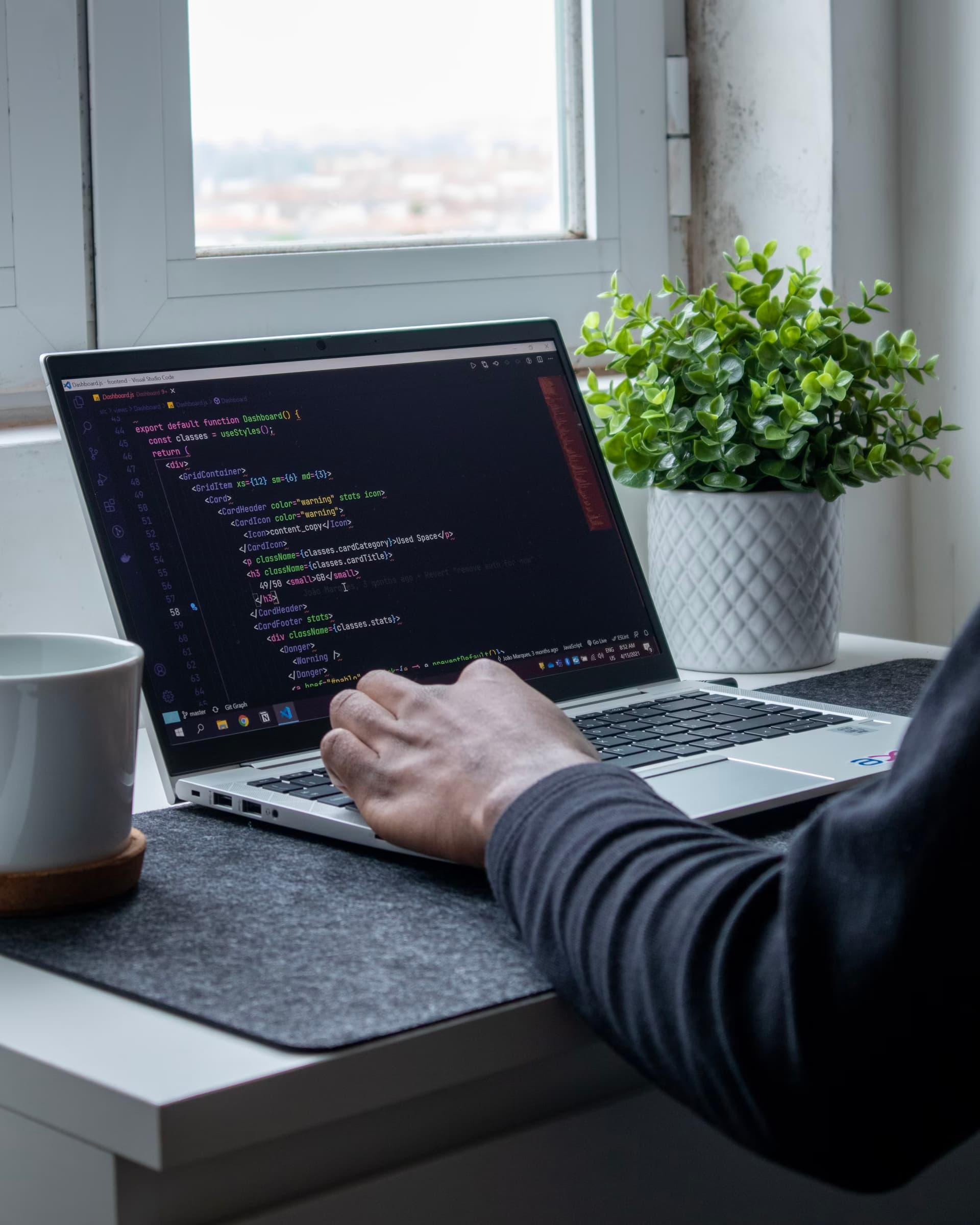 someone in front of a laptop with a code screen display